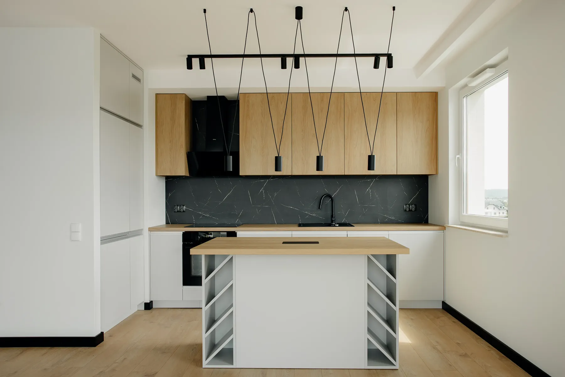 Kuchnia z wyspą i półkami na wino